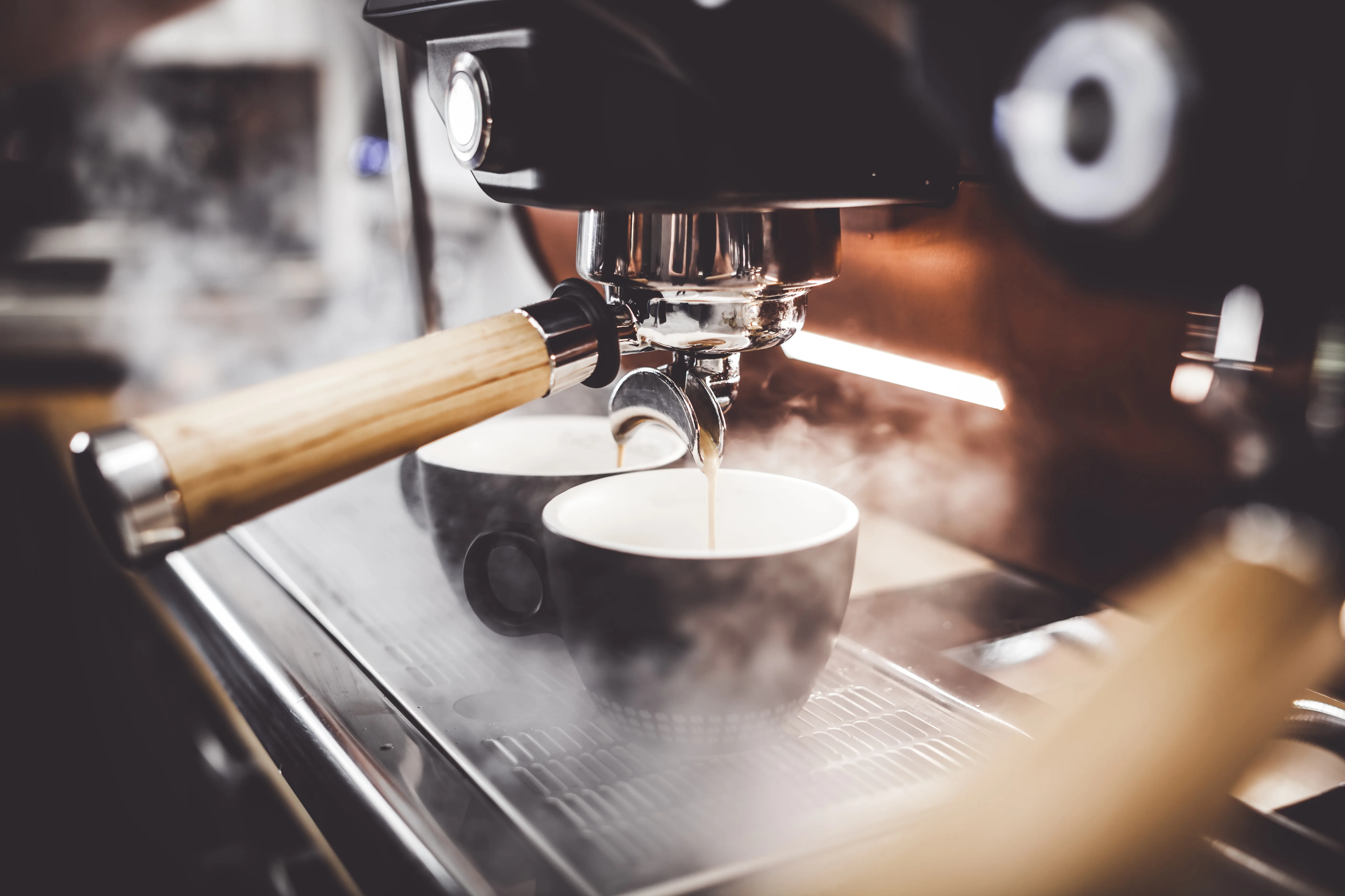 Espresso being pulled into two warm cups